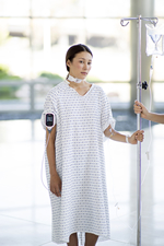 standing patient wearing Radius-7 on their arm while holding a IV stand