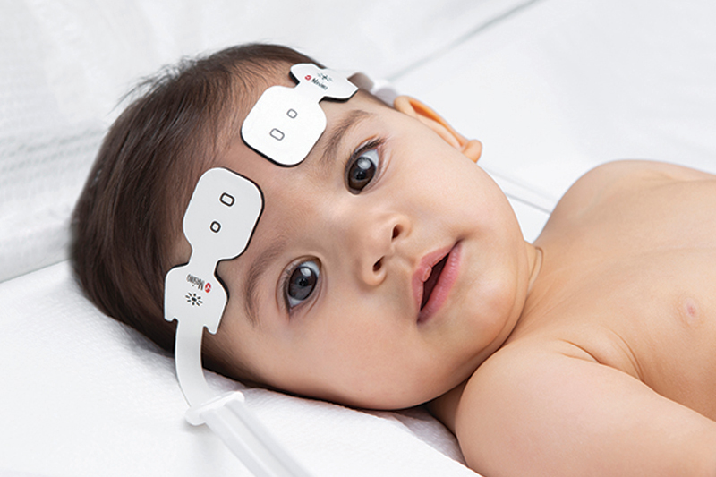 Infant in bed wearing Masimo O3 Sensors.